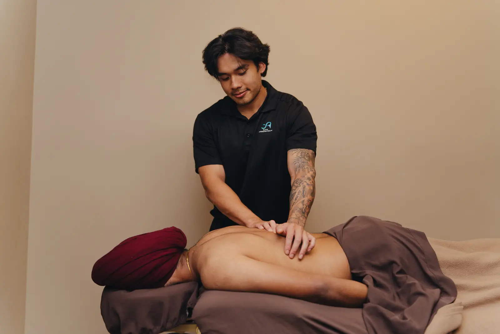 Registered massage therapist David Vo treating a client's back at the Ventura Avenue clinic