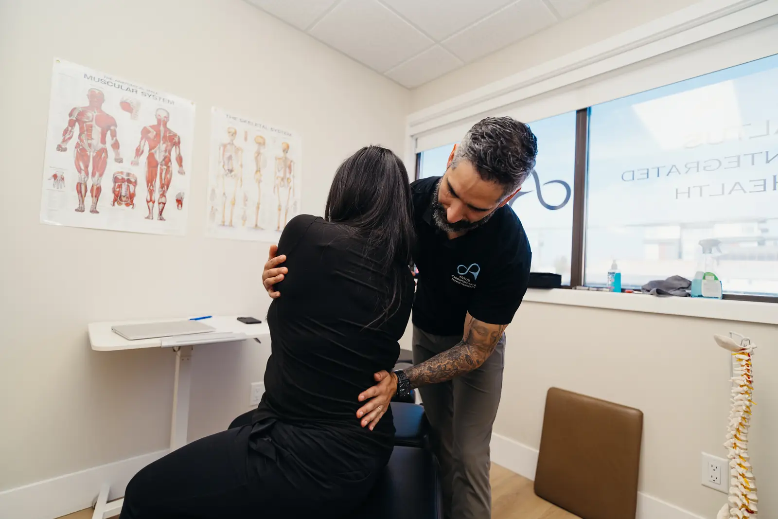 Dr. Jose Otano, DC working with a seated patient