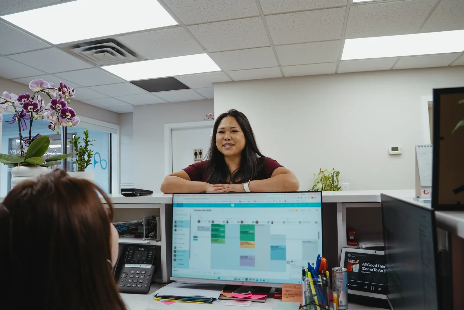 Dr. Trang Luu-Grover at the front desk with the team
